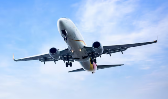 Front view of a large cargo airplane on the runway with mountains in the background.